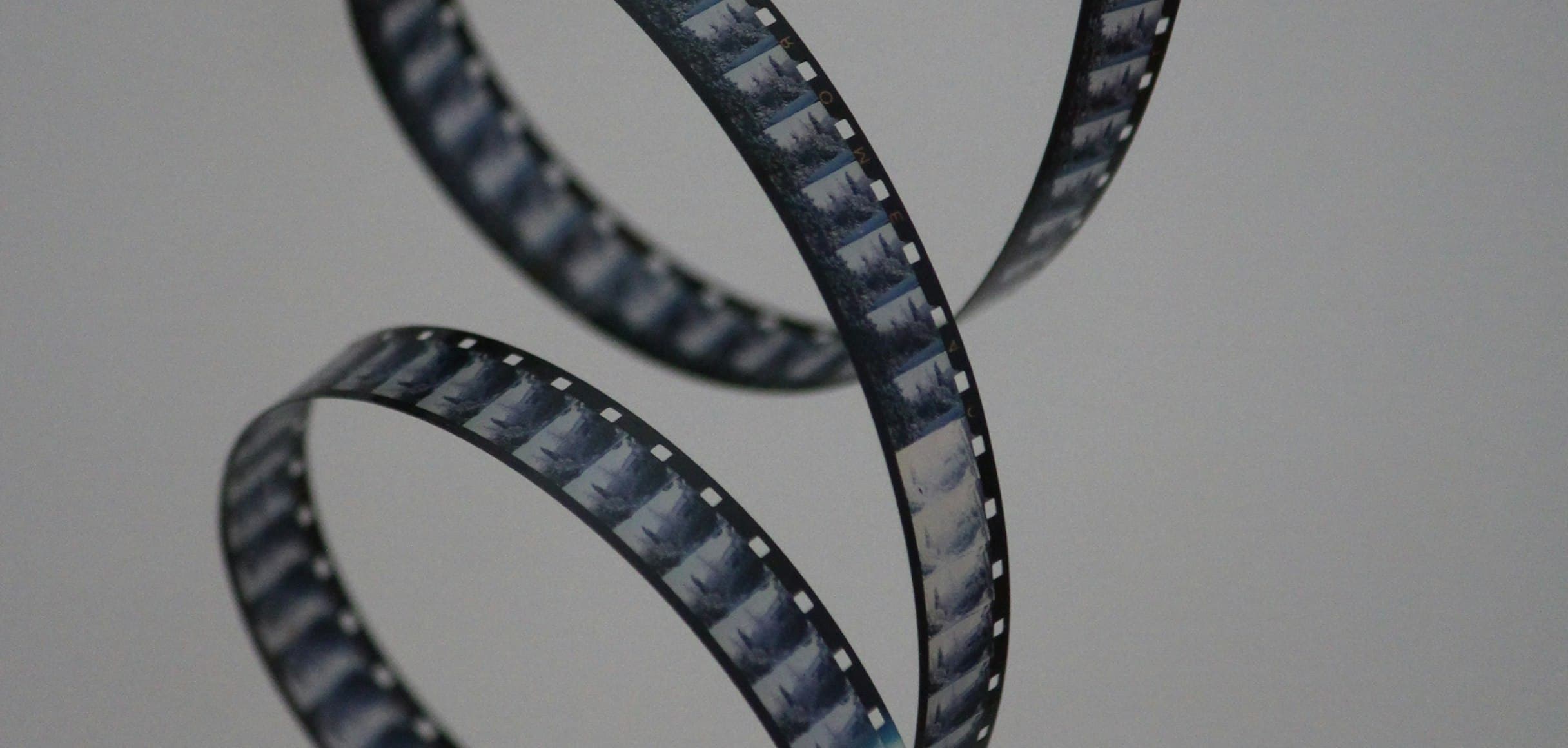 A curled strip of 35mm film against a dark background